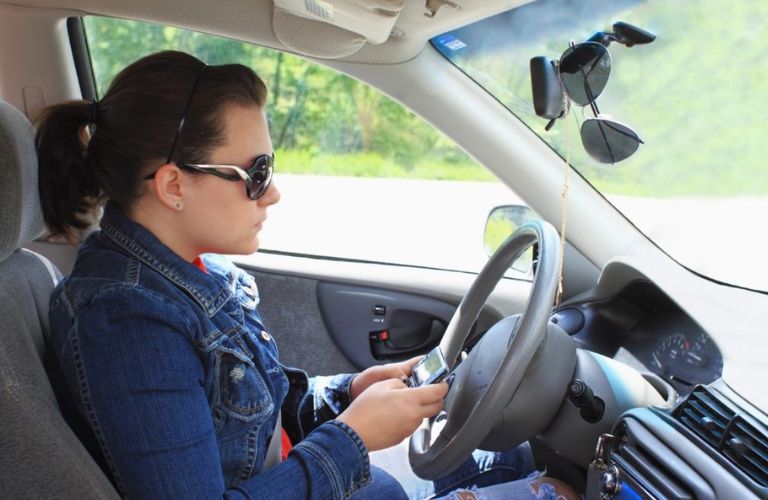 Woman using phone while driving